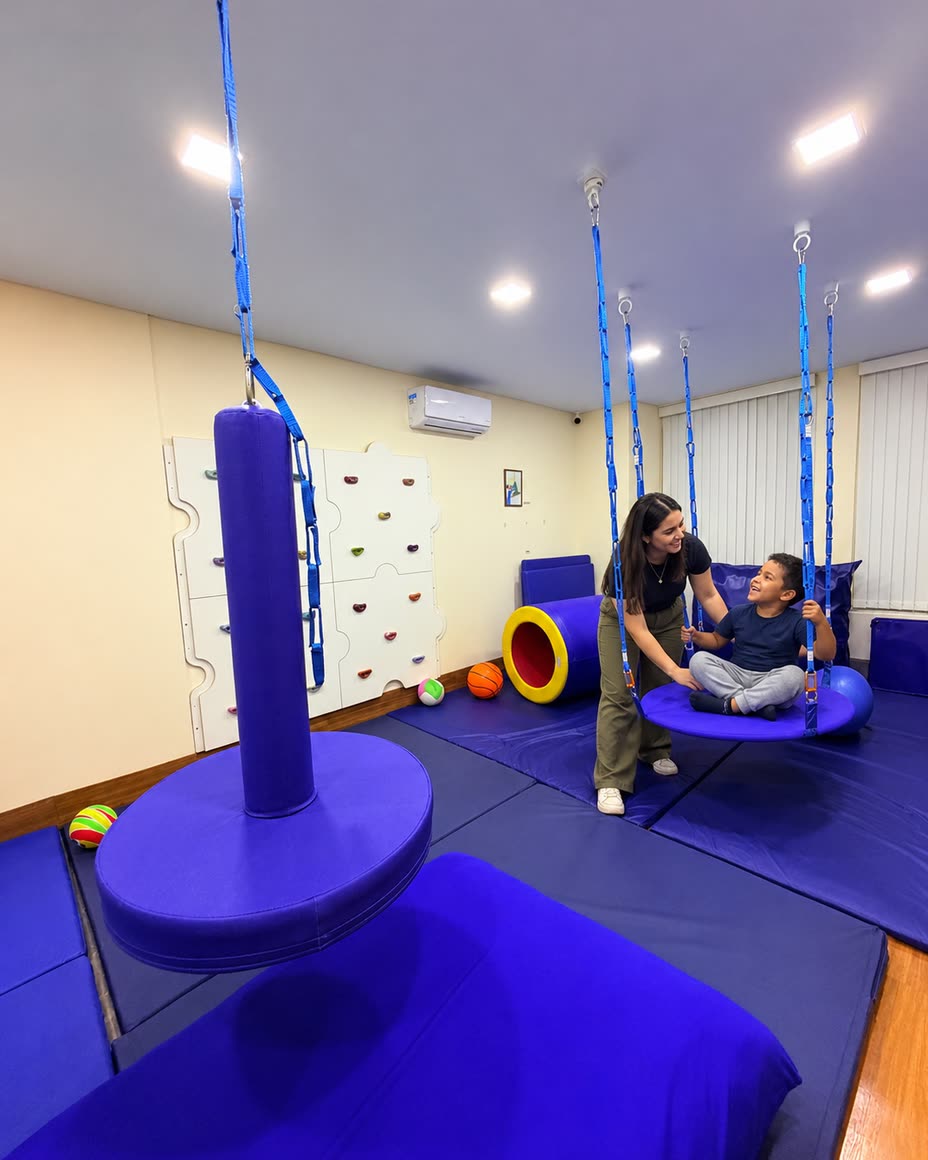 Sala de integração sensorial com balanços suspensos e tatames